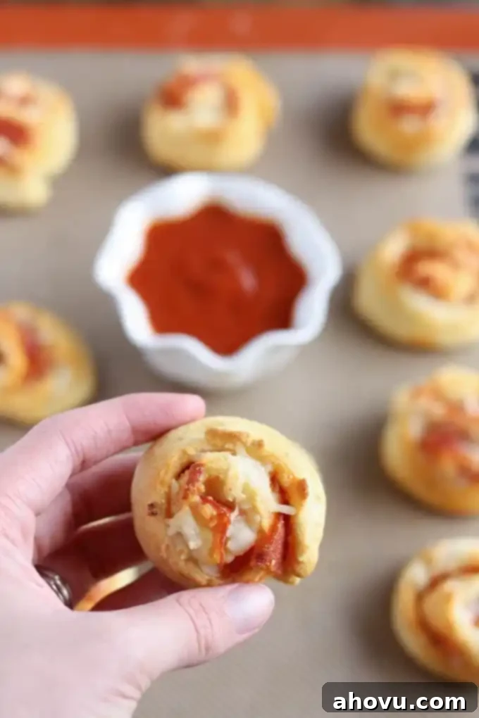 Golden brown Pizza Pinwheels cooling on a baking sheet, ready to be served