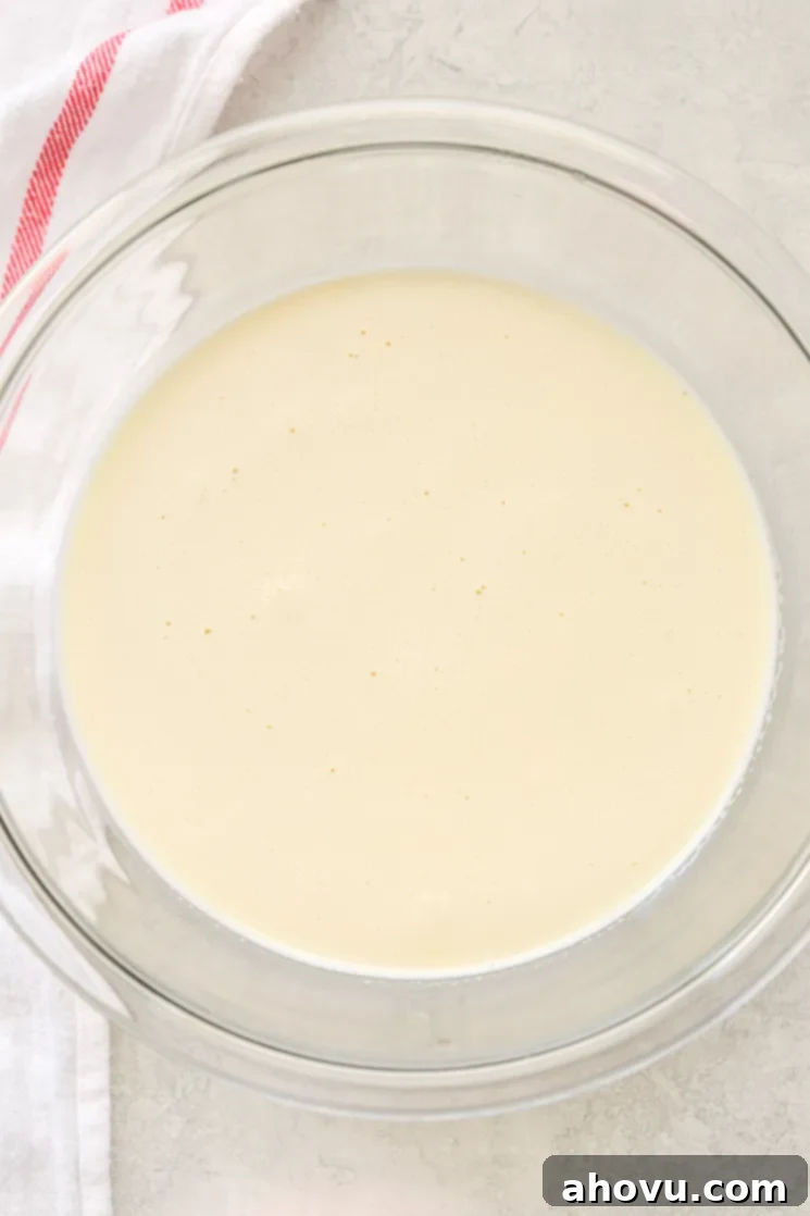 A clear glass bowl filled with the crème brûlée mixture and a white napkin on the side of the bowl.