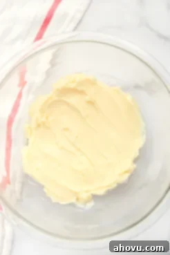 A glass bowl filled with butter that's been mixed together with powdered sugar.