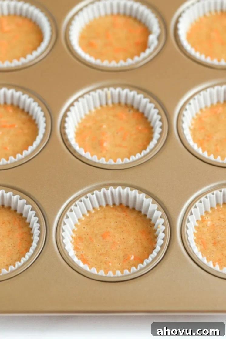 Perfectly Spiced Carrot Delights 4 A muffin pan filled with cupcake liners and carrot cake cupcake batter.