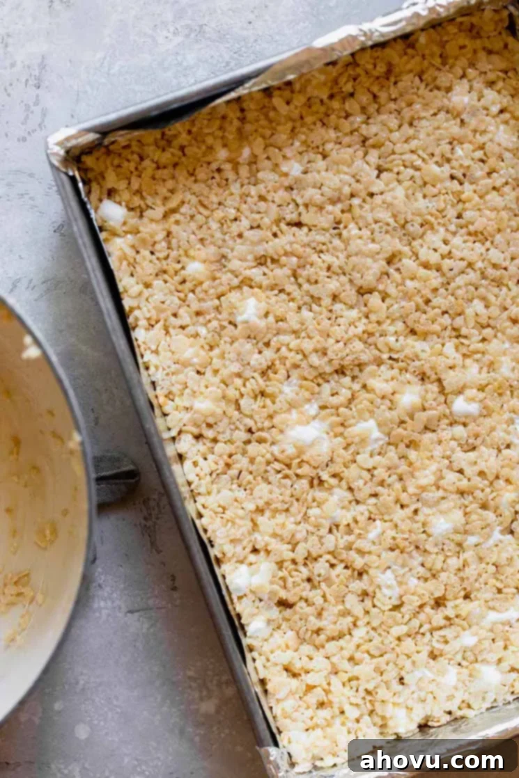 A metal baking pan with the Rice Krispie bar mixture pressed into it. 