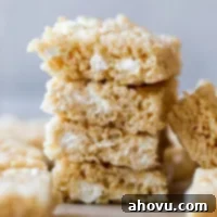 A stack of Rice Krispie treats on top of a wooden tray.