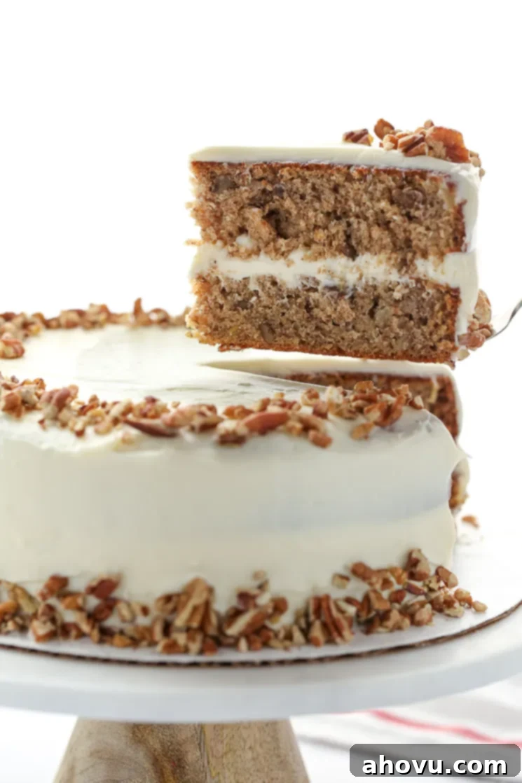 Sweet Nectar Cake 7 A magnificent whole hummingbird cake displayed on a stylish marble cake stand, with one perfect slice carefully removed, revealing the delicious layers of cake, fruit, and frosting.