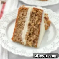 Sweet Nectar Cake 8 A delectable slice of hummingbird cake on a pristine white plate, showcasing its moist layers and creamy frosting.