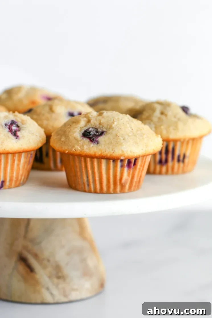 Blueberry muffins on top of a marble cake stand.
