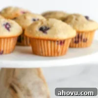 Blueberry muffins on top of a marble cake stand.