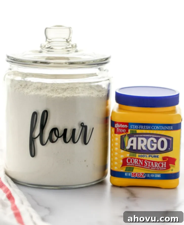 A container of cake flour and cornstarch sitting on top of a marble surface.