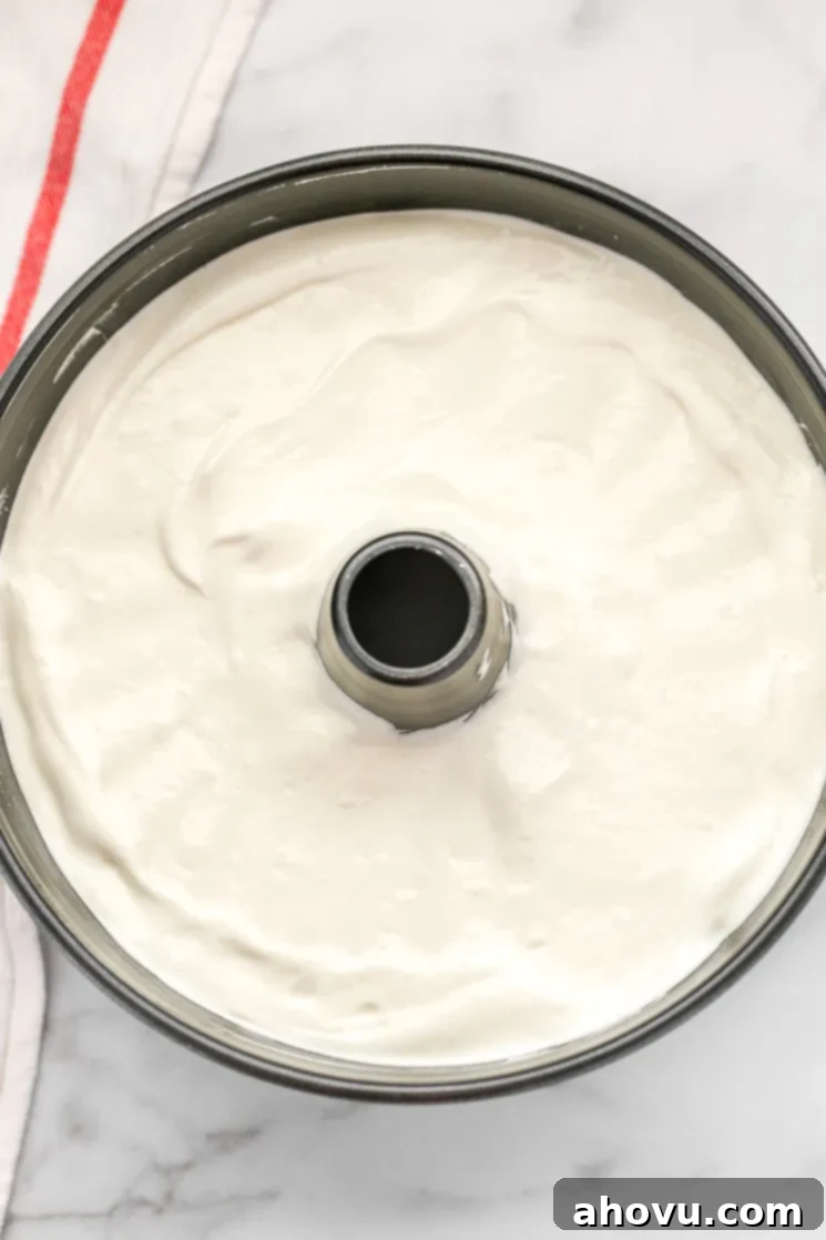 An ungreased angel food cake pan filled with perfectly smooth, light angel food cake batter, ready to be baked.
