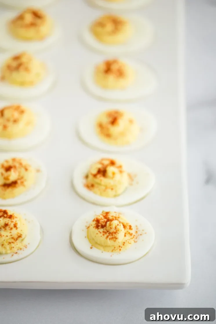 Spiced Yolk Delights 2 Deviled eggs topped with smoked paprika in a deviled egg tray, ready to be served.
