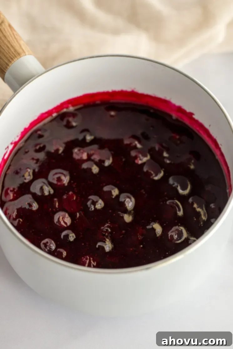 A white saucepan filled with the cooked blueberry sauce.