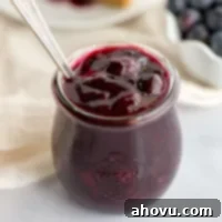A close-up picture of a jar filled with homemade blueberry sauce.