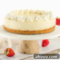 A cheesecake topped with whipped cream sitting on a marble cake stand.