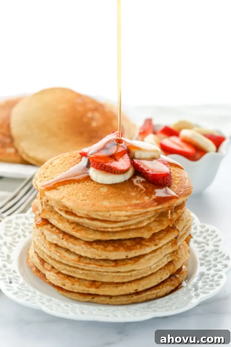 Wholesome Wheat Stacks 5 A stack of whole wheat pancakes topped with sliced strawberries and bananas drizzled with pure maple syrup.