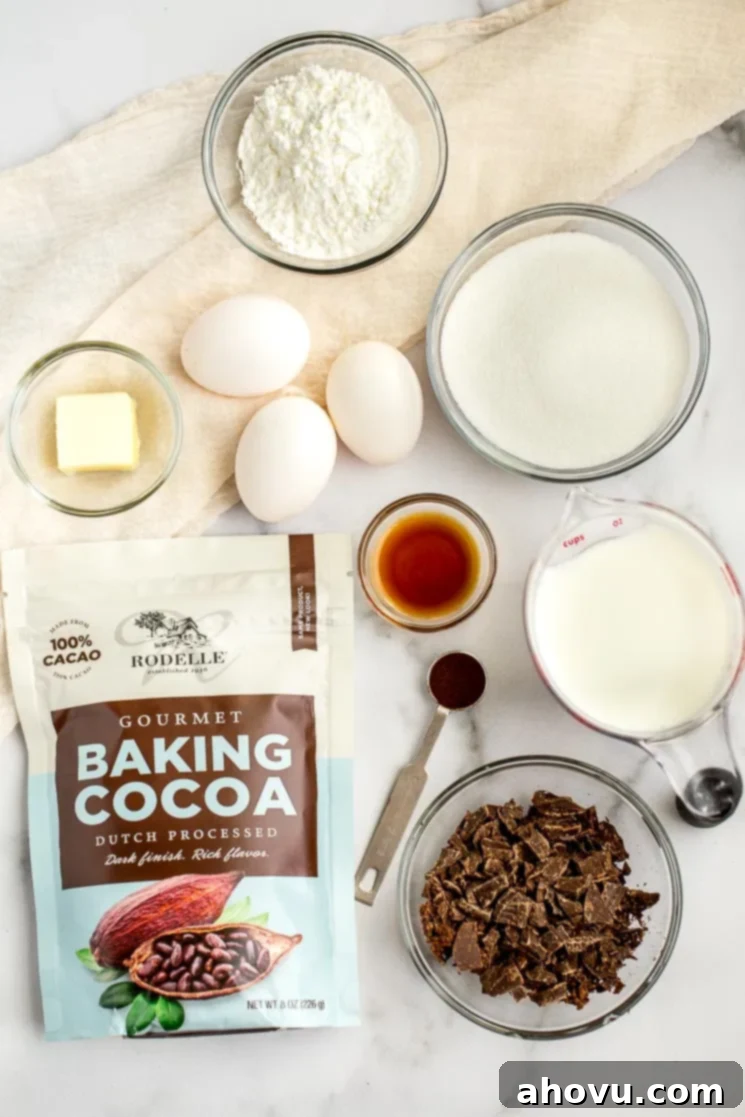 Various ingredients for the chocolate cream pie filling, including cocoa powder, sugar, milk, and eggs, arranged neatly on a sleek marble surface.