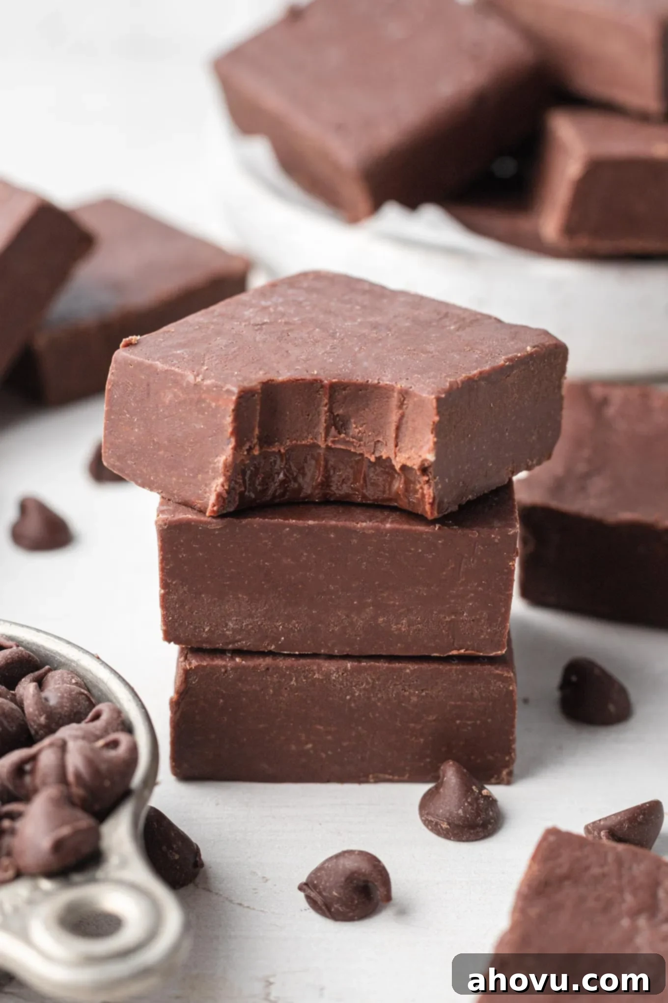 Foolproof Fudge in Minutes 2 A stack of chocolate fudge slices. The top slice has a bite missing.