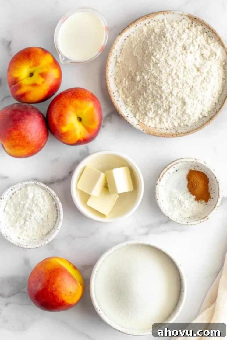 Grandma's Classic Peach Cobbler 3 The ingredients for peach cobbler laid out in various bowls and plates on a marble surface, showcasing fresh peaches, flour, sugar, butter, and spices.