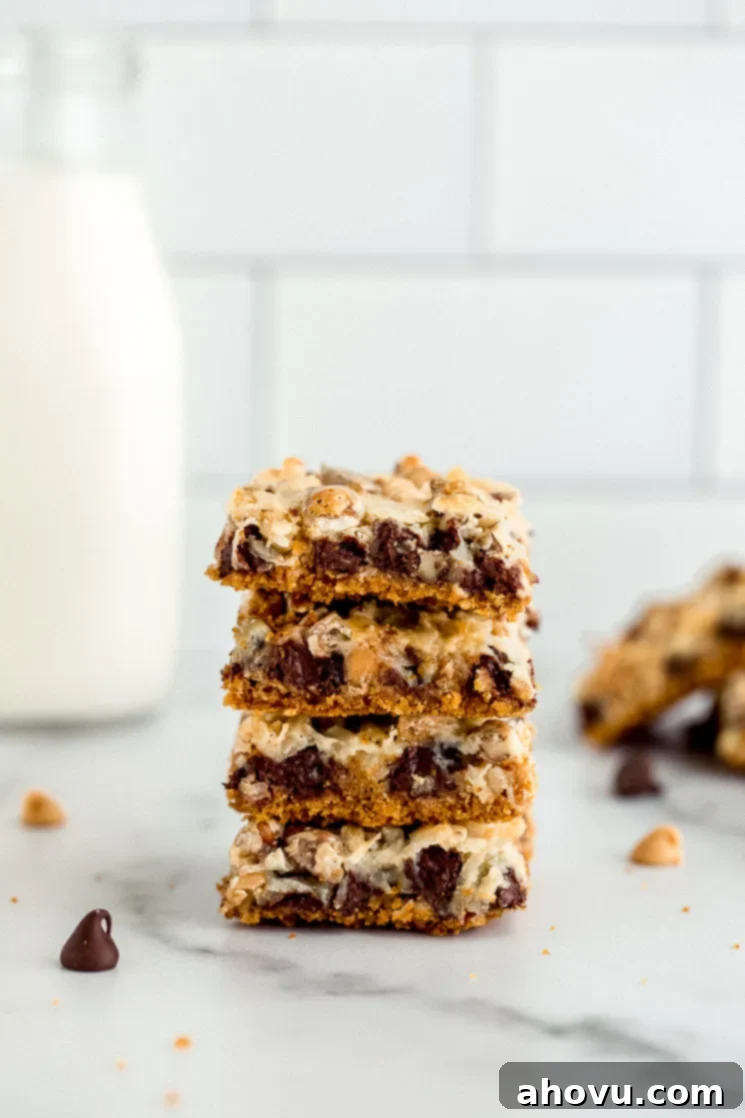 Irresistible Magic Bars 2 A delectable stack of golden-brown Magic Cookie Bars, also known as 7 Layer Bars, sitting on a polished marble surface, showcasing their delicious layers of chocolate, nuts, and coconut.