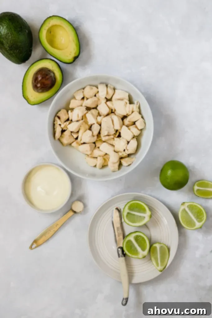 The ingredients needed to make avocado chicken salad in different bowls and measuring cups.