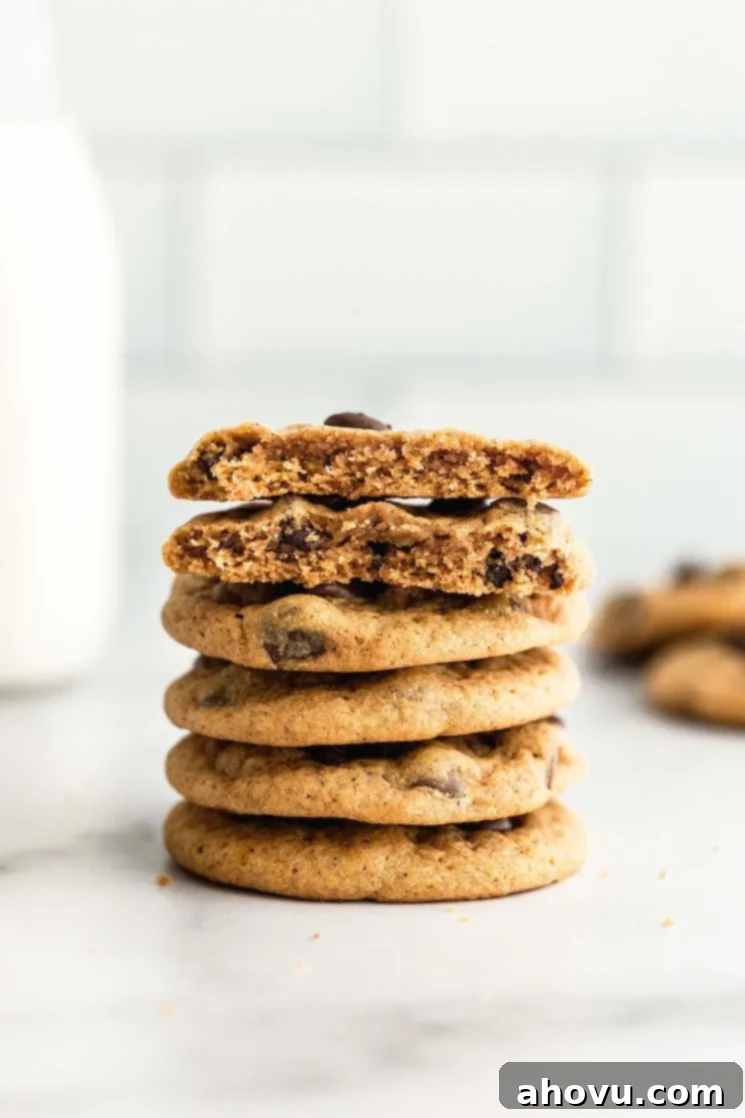 A stack of pumpkin chocolate chip cookies with milk in the background.