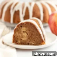 Orchard Apple Delight 6 A slice of apple cake on a white plate, ready to be enjoyed.