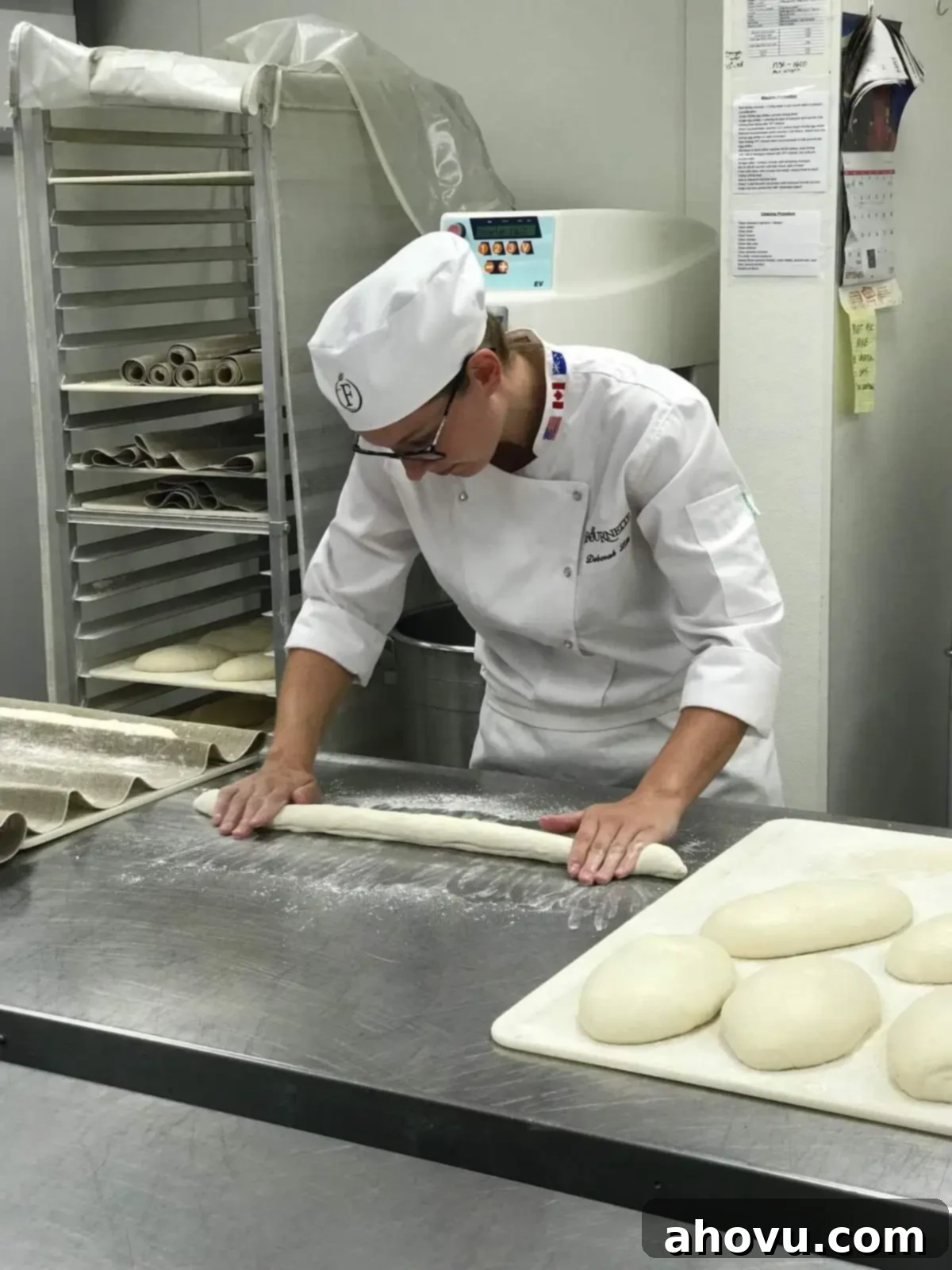 A picture of a woman rolling and shaping French baguettes.