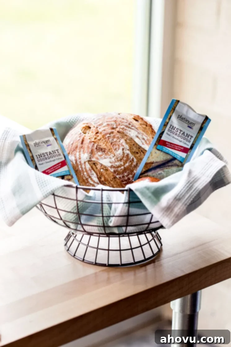 A picture of a loaf of bread in a basket with Red Star Platinum Instant Sourdough Yeast around it.