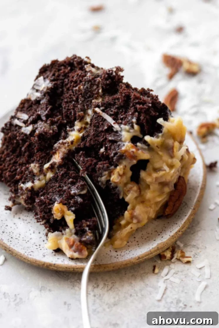 Coconut Pecan Chocolate Dream 6 A delectable slice of German Chocolate Cake artfully presented on a rustic clay plate, with a fork gently cutting into a piece, inviting a bite. The layers of cake and frosting are perfectly visible.