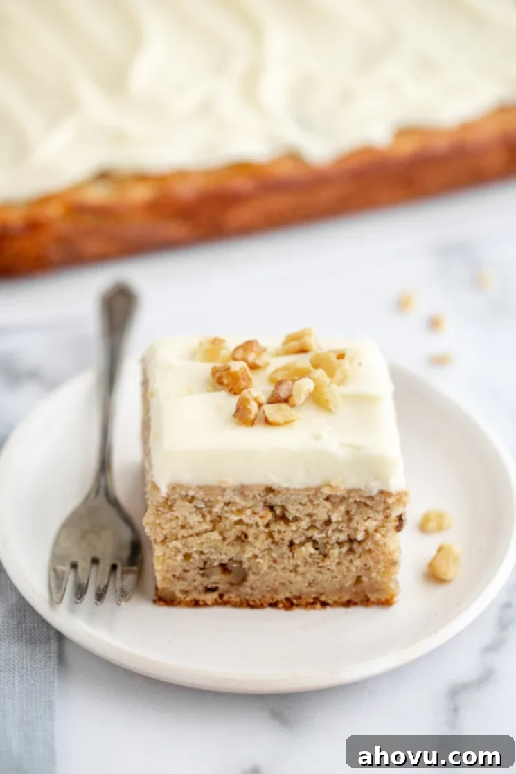 Banana Cake 7 A piece of banana cake sitting on an antique white plate and the rest of the cake in the background on a marble surface. A delectable slice of banana cake, ready to be enjoyed.