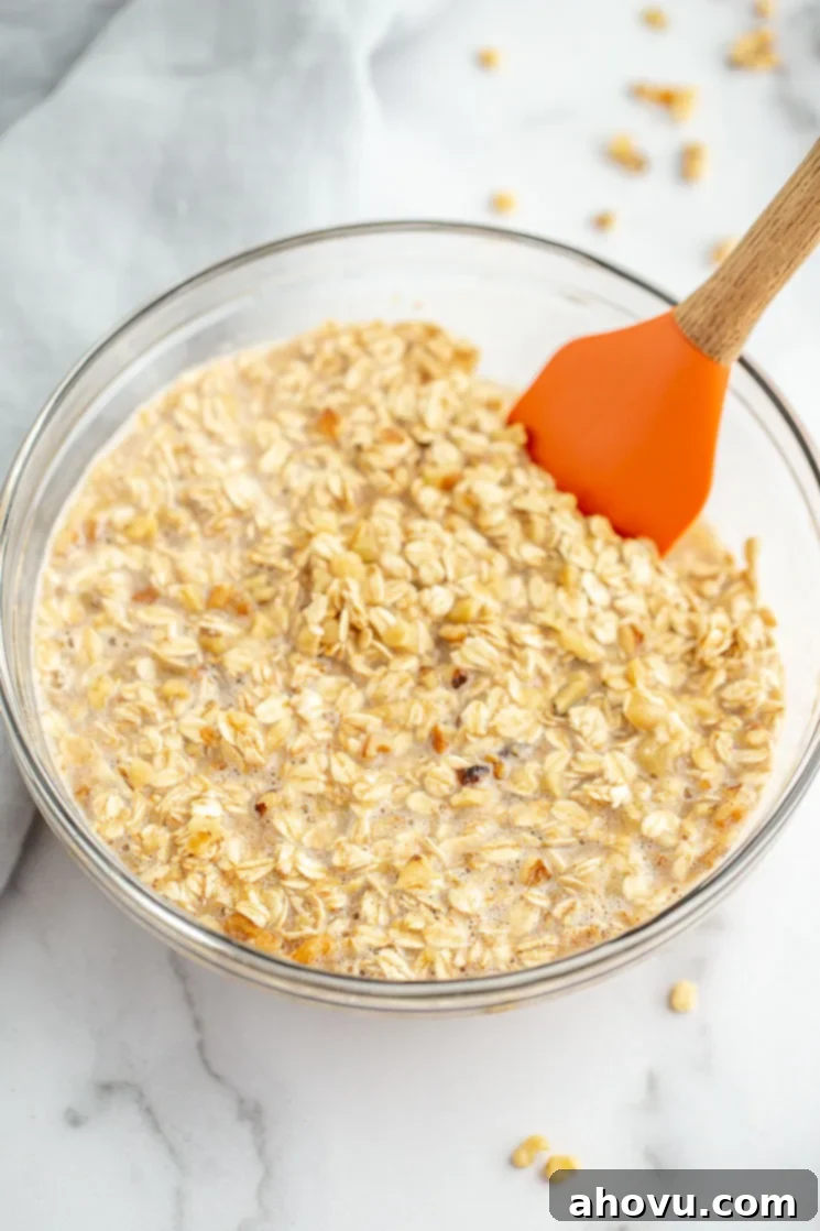 A glass mixing bowl containing the wet and dry banana oatmeal mixture before being portioned.