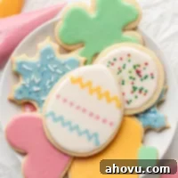 Several iced sugar cookies on a white plate.