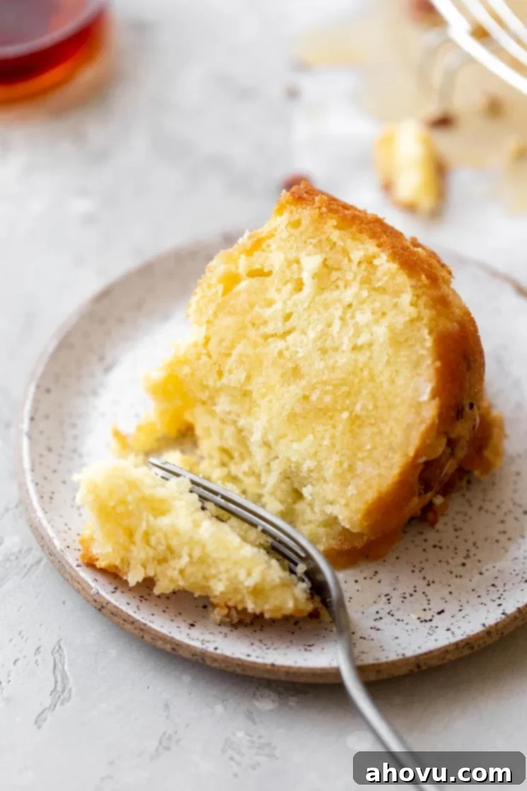 A single slice of cake on a rustic clay plate and a bite taken out with a fork.