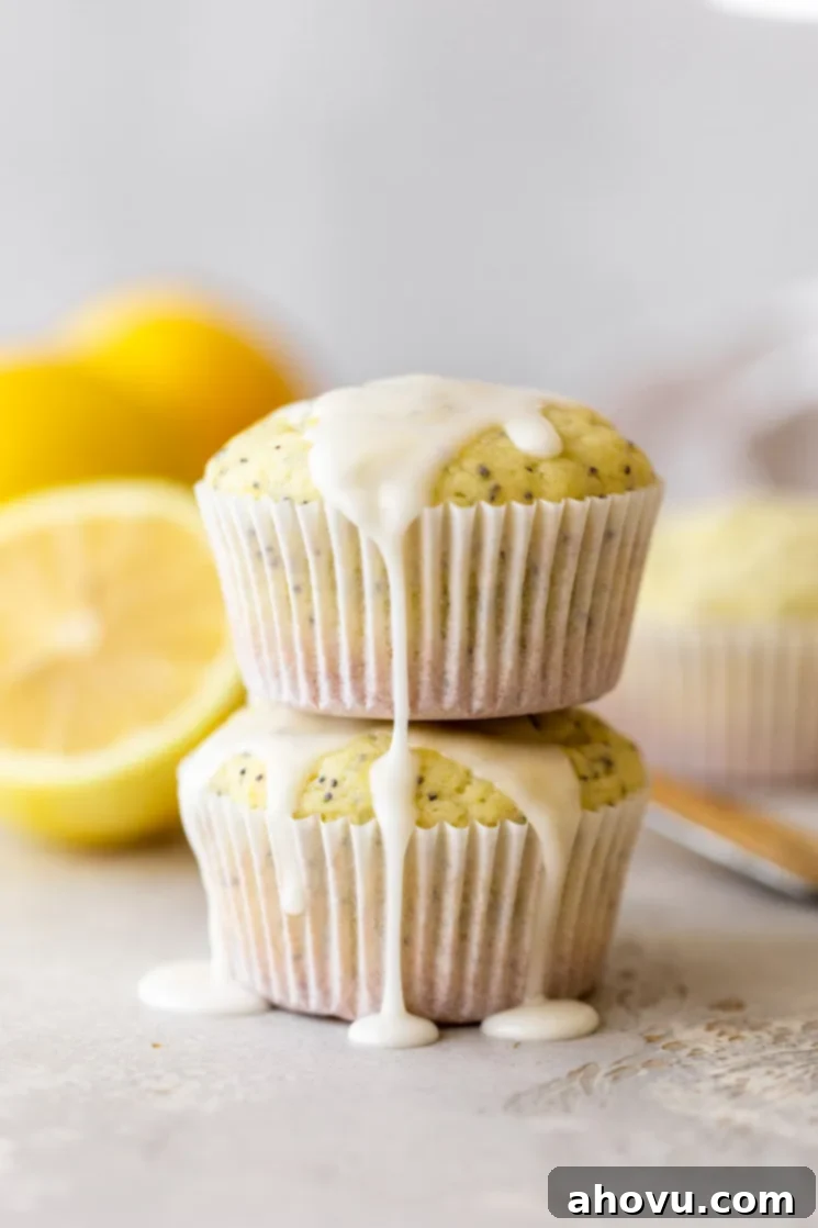 Two muffins stacked with lemon glaze on top and running down the sides.
