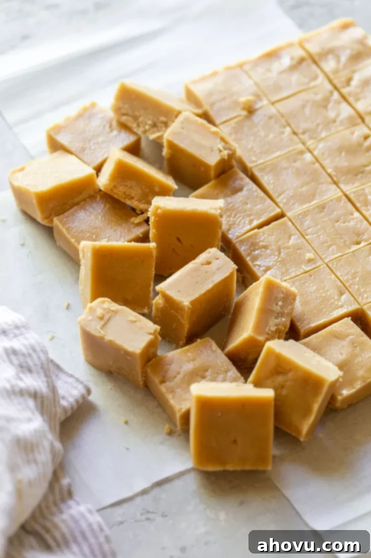 Peanut butter fudge cut into neat square pieces, arranged on parchment paper, ready to be enjoyed.