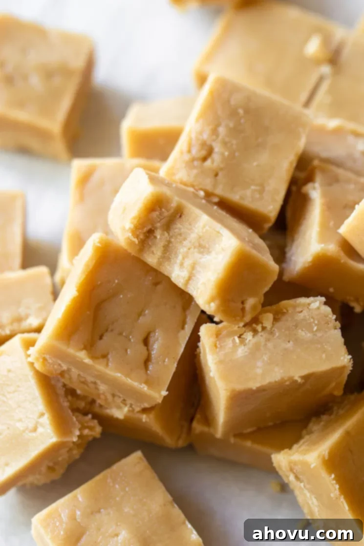 Pieces of Peanut Butter Fudge stacked with the top piece having a bite taken out, showing its soft interior.