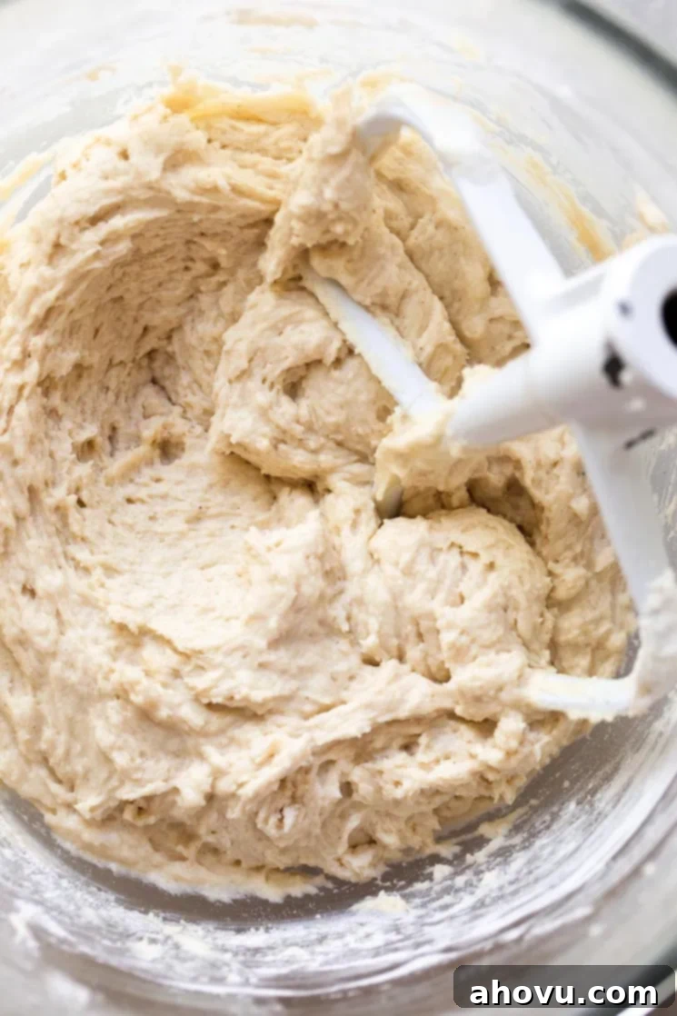 A glass mixing bowl filled with smooth, creamy cake batter.