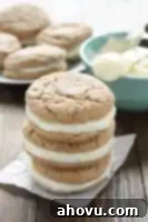 Carrot Cake Whoopie Pies 4 A top-down shot of a single carrot cake sandwich cookie, showing the soft cookie texture and generous cream cheese filling, on a white background.