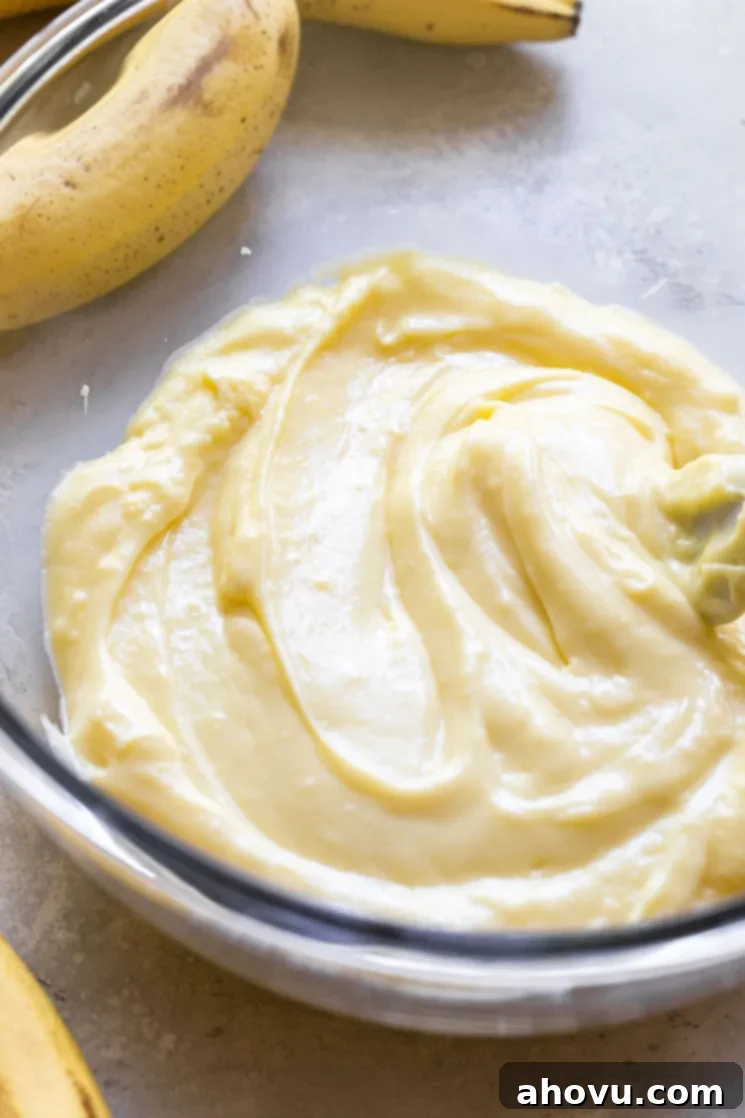 The creamy vanilla filling in a glass mixing bowl ready to pour into the prepared pie crust.