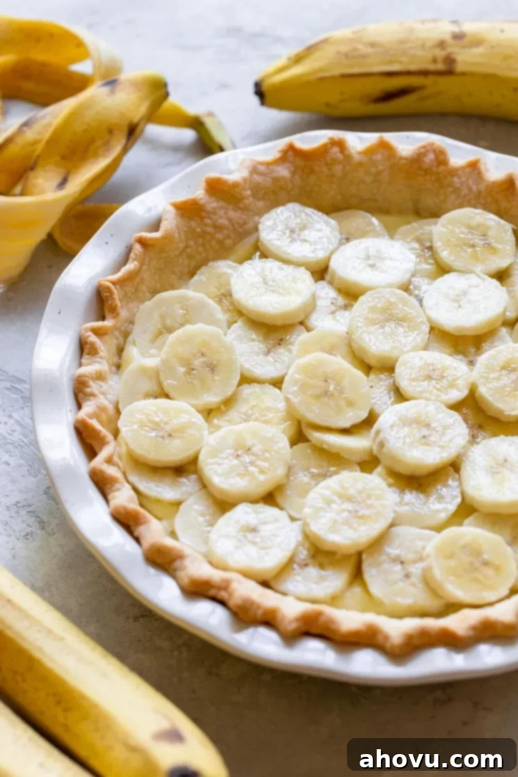 A pie crust filled with a layer of custard filling and sliced bananas.