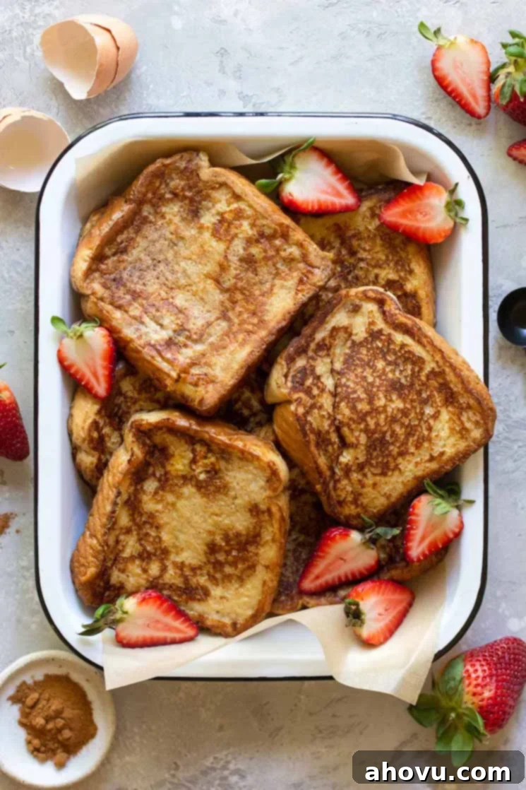 Fluffy French Toast Perfection 2 A baking pan filled with finished French toast surrounded by strawberries and spices.