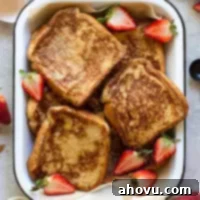 Fluffy French Toast Perfection 8 A baking pan filled with finished French toast surrounded by strawberries and spices.