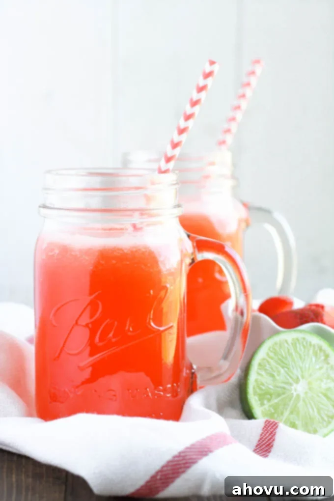 Strawberry Limeade being poured into a glass from a pitcher