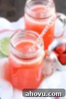 A glass of homemade strawberry limeade with fresh fruit garnish.