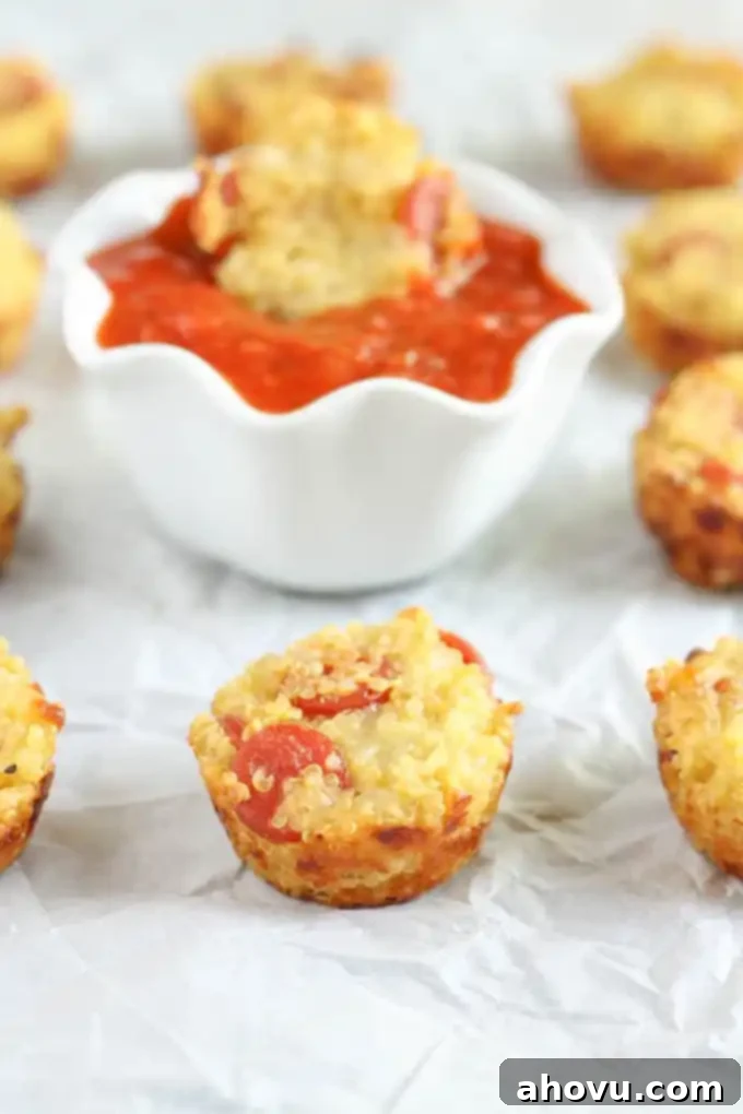 Several mini quinoa pizzas artfully arranged on a piece of parchment paper, showcasing their golden crusts and melted cheese toppings.
