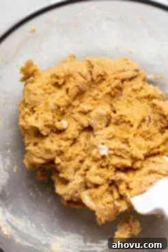 The perfectly mixed pumpkin scone batter in a glass mixing bowl, ready to be shaped into a disc.