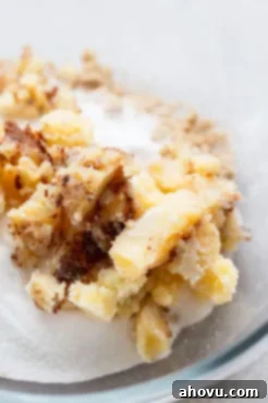 A glass mixing bowl holding the brown butter and sugars for the cookies.