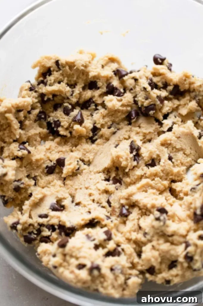 A glass mixing bowl holding the finished brown butter chocolate chip cookie dough. 