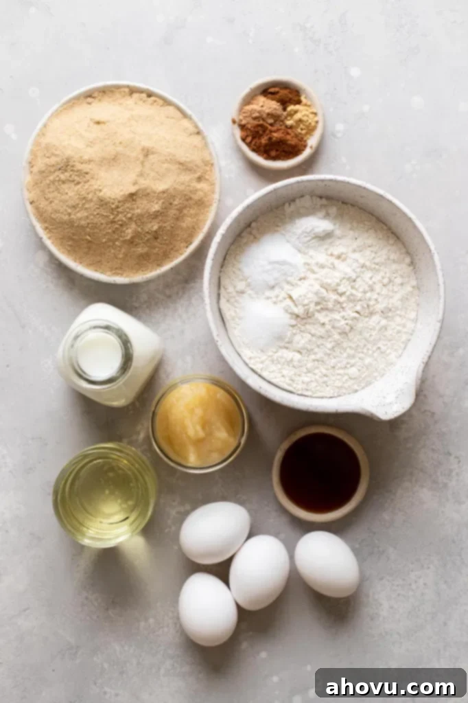 Golden Spiced Comfort 3 A curated display of all the essential ingredients laid out on a clean gray surface, ready for making a homemade spice cake, including flour, sugar, spices, eggs, buttermilk, oil, and applesauce.