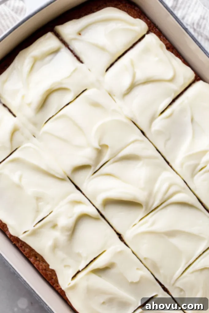 Golden Spiced Comfort 5 A beautifully finished spice cake, generously topped with swirling cream cheese frosting, is sliced into neat squares directly in the baking pan, ready to be served and enjoyed.