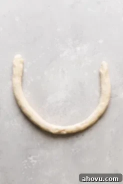 A roll of raw pretzel dough formed into a U shape.