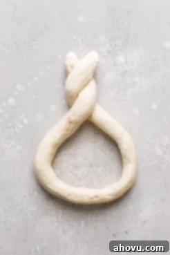 A roll of raw pretzel dough formed into a twisted pretzel shape.